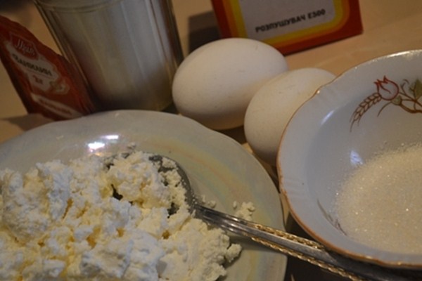 В миску положить творог, размять его. Яйца взбить с сахаром и добавить к творогу