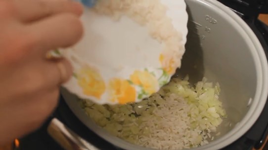К обжаренному луку добавляем, предварительно сваренный до полуготовности рис, солим